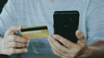 mains tenant une carte de crédit et utilisant un ordinateur portable. shopping en ligne video