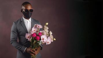 Portrait of African Man in Formal Suit and Holding Beautiful Bouquet on Dark Background. . photo