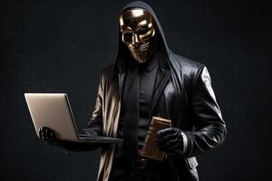 A Criminal Person Wearing Silver Mask with Black Jacket and Holding Laptop, Wallet or Payment Card. . photo