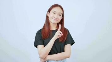 asiático niña vistiendo un negro camiseta ella Ofrecido ánimo por demostración dos pulgares arriba simbolos video
