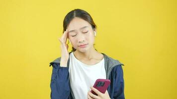 mujer teniendo dolor de cabeza mientras vistiendo auriculares, dolor mientras jugando teléfono inteligente video