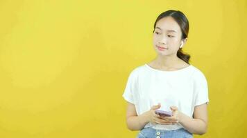 Close-up video of Asian woman wearing headphones while listening to music through smartphone application and online merchandising promo scene.