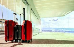 stack of traveling luggage in airport terminal building with passenger plane flying background photo