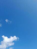 Beautiful white clouds on deep blue sky background. Large bright soft fluffy clouds are cover the entire blue sky. photo