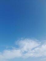 White clouds in the blue sky. Beautiful bright blue background. Light cloudy, good weather. Curly clouds on a sunny day. photo