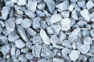 grava textura. gris grande ligero piedras, guijarros sin costura antecedentes foto