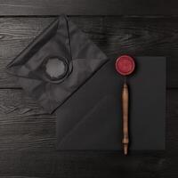 Overhead View of Wax Sealed Black Old Letter Envelope with Engraving Needle on Desk. . photo