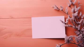 Pink Blank Paper Card Mockup and Mulberry Flower Branch on Coral Wooden Texture Table Top, . photo