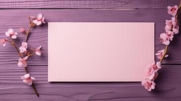 Top View of Blank Paper Card Mockup and Beautiful Cherry Floral Branches on Wooden Table. . photo