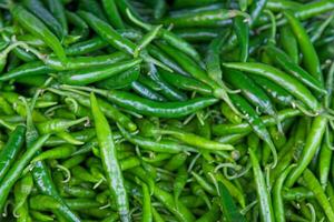 Stack of Green Chillis on a market stall photo