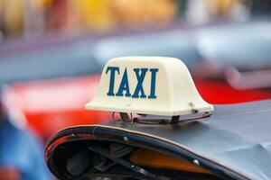 Taxi sign on the roof of a tuk tuk photo