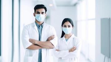 Young Male and Female Doctor Wearing Masks While Standing Together in Hallway of Hospital, . photo