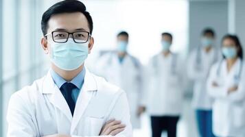 Portrait of Asian Doctor Wearing Mask and His Medical Team Standing in the Hospital Hallway, . photo