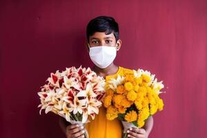 Portrait of Indian Teenager Boy Wearing Mask and Holding Two Bouquet, Generative AI. photo