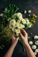 Top View Closeup of Female Florist Creating Beautiful Bouquet from White Dahlia at Workplace, Generative AI. photo