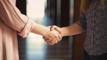 Friendly or casual handshake between two women. Close up. . photo