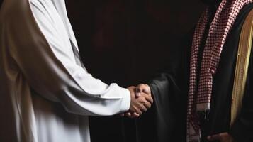 Business handshake between two Arabian Man. Close up on black Background. . photo