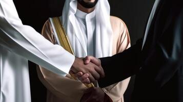 Business handshake between two Arabian Man. Close up on black Background. . photo