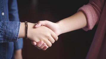 Friendly or casual handshake between two women. Close up. . photo