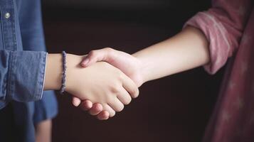 Friendly or casual handshake between two women. Close up. . photo