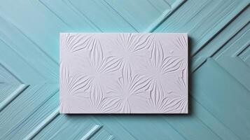 Top View of Flower Embossing Paper Card on Blue Plank Geometric Texture Table, . photo