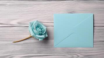 Top View of Pastel Blue Color Blank Paper Card Mockup with Beautiful Rose on Wooden Table, . photo