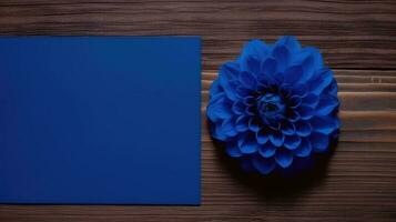 Blank Blue Paper Card Mockup with Dahlia Flower on Wooden Table Top, Generative AI. photo