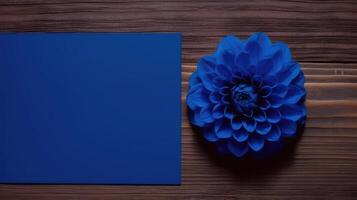 Blank Blue Paper Card Mockup with Dahlia Flower on Wooden Table Top, . photo