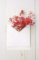 Top View of Red Gypsophila Flower Branch in Open Envelope on Wooden Table, Generative AI. photo