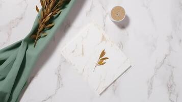 Top view of Blank White Card with Dry Leaves, Green Silk and Wax Glass on Marble Background. . photo