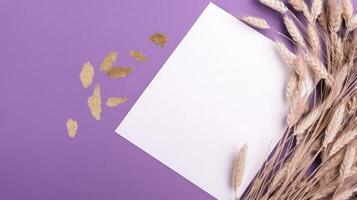 Top View of Blank White Paper with Dried Wheat on Purple Background and Placement. Vintage Delicate Business or Wedding Card Design. . photo