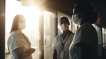 Professional Female Physicians Wearing Face Masks, Communicating Each Other in Hospital Room and Sunlight Through Window. . photo