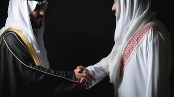 Cropped Image of Business Handshake Between Two Arabic Men in Their Traditional Attire. . photo