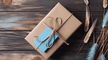 Top View of Rustic Packed Gift Box with Burlap Thread, Feather and Dried Grass on Vintage Wooden Table, . photo