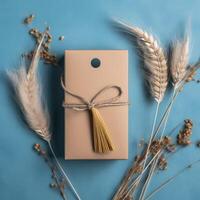 Top View of Kraft Packet Tied with Burlap Thread, Dried Grain Grass and Seed Stems on Blue Background, . photo