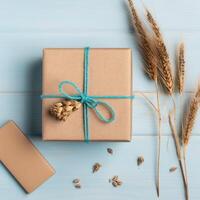 Top View of Rustic Style Packed Gift Box and Golden Dried Grain Grass on Pastel Blue Wooden Table, . photo