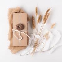 Top View of Rustic Style Packed Rectangle Gift Box, Burlap Thread Ball, Dried Grain Grass on White Background, . photo