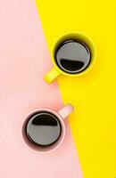 Flat lay of a two coffee cups with pink and yellow photo
