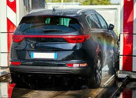 Black car in automatic car wash photo