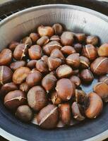 Roasted chestnuts in an iron pan photo