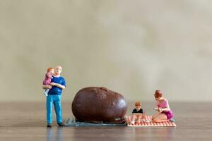 Miniature people Happy family enjoying chocolate photo