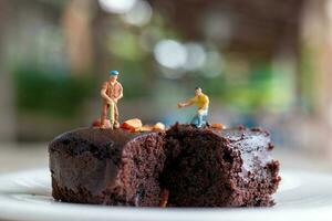 miniatura gente, un empleado es haciendo un chocolate duende foto