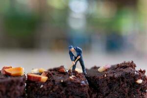 miniatura gente, un empleado es haciendo un chocolate duende foto