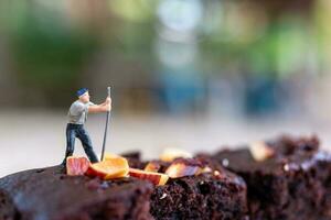 miniatura gente, un empleado es haciendo un chocolate duende foto