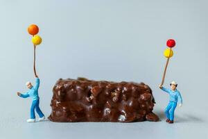 Kids with chocolate bars standing on gray background. World Chocolate Day Concept photo