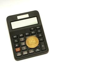 calculadora y moneda bitcoin aislado en blanco fondo, cálculo de rentabilidad. foto