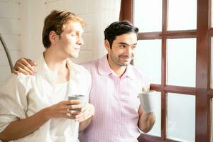 lgbt gay Pareja participación taza de café. Pareja de gay hombres Bebiendo café a hogar, gay orgullo y matrimonio estilo de vida. foto