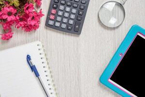 Notebook, pen, Magnifier, calculator and tablet pc, on wood table background. Business concept.. photo
