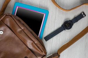 Flat lay of businessman tablet with watch and smartphone on table, top view. photo