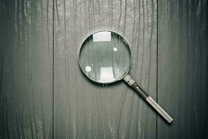 Close up Single Magnifying Glass with Handle on the Wooden Table photo